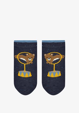 Gebreide sokken in marineblauw met lichtblauwe boorden. Met daarop een bruin dier op een gele circusbasis, met sterren en kleurrijke accenten door het geheel.