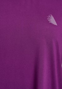 Lila Sport-T-Shirt aus dehnbarem Stoff, mit einem strukturierten weißen Logo-Highlight auf der oberen linken Seite.