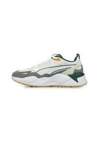 Zapatilla blanca y gris con un upper texturizado, acentos en verde y detalles en naranja, que cuenta con una suela gruesa y paneles perforados.