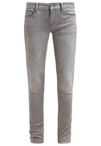 Jeans de mezclilla gris ajustados con una textura suave, diseño de cinco bolsillos y un sutil detalle de desvanecimiento en la parte delantera y trasera. Botón y cremallera plateados.