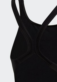 Top deportivo negro sin mangas con tirantes anchos y un diseño de espalda en forma de Y. Hecho de una tela suave y elástica con detalles de costura reforzada.