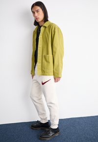 Nike Sportswear JOGGER - Παντελόνι φόρμας - light orewood brown