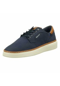 Navy canvas sneaker with leather accents, white textured rubber sole, round toe, lace-up design, and contrasting stitching details.