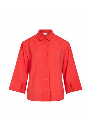 Chemise rouge à manches longues avec boutons, poignets larges fendus et col classique, présentée sur un fond blanc uni.