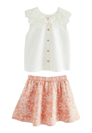 Top blanco sin mangas con cuello de encaje y botones en la parte delantera, combinado con una falda de estampado floral rosa que cuenta con una cinturilla elástica.