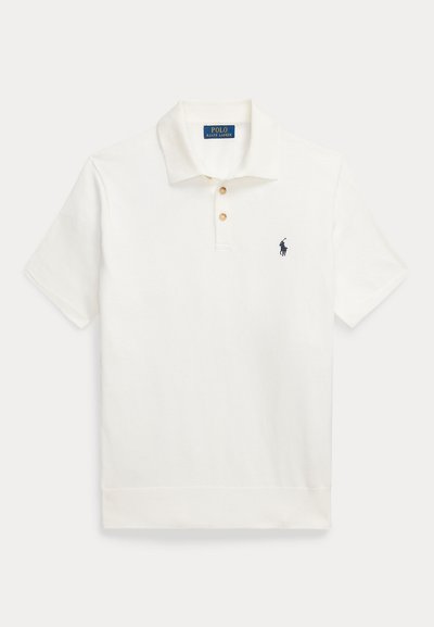 Λευκό πουκάμισο Polo Ralph Lauren με κοντά μανίκια, δύο κουμπιά και κεντημένο λογότυπο με άλογο σε ναυτικό μπλε χρώμα στο αριστερό στήθος.