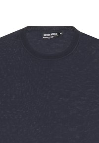 Maglione in merino blu navy con una consistenza a maglia fine, colletto a coste e una leggera lucentezza, con un'etichetta centrale che mostra marca e taglia.