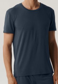 Ciemnogranatowy t-shirt z krótkim rękawem, wykonany z miękkiego, gładkiego materiału, z okrągłym dekoltem, charakteryzujący się luźnym krojem i prostym wykończeniem.