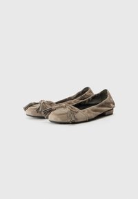 Ballerines en daim gris avec des accents de franges, bout arrondi, petit talon et texture douce. Détails de couture le long du bord.
