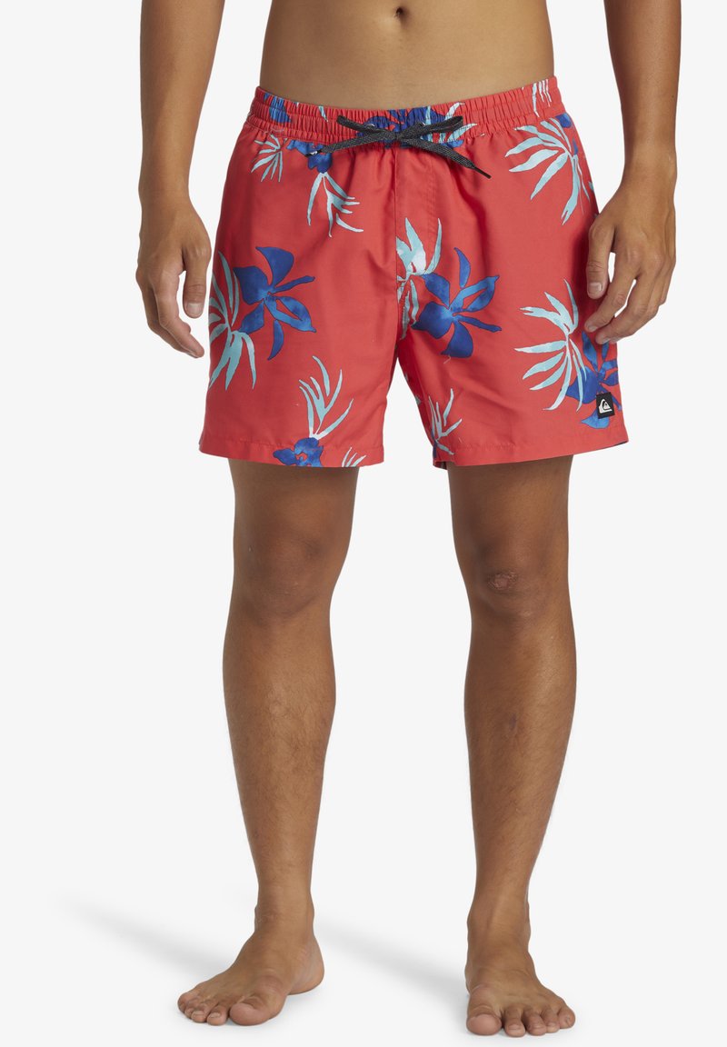 Bañador rojo con estampado floral azul, con una cintura elástica y cordón. Hecho de material liviano, ideal para usar en la playa.