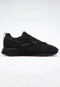 Baskets basses noires Reebok avec panneaux en daim et mesh, semelle rainurée et logo latéral de la marque, vues en profil droit sur fond blanc.