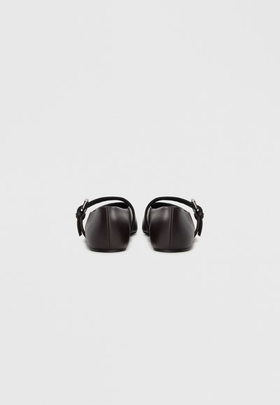 Καφέ δερμάτινα μπαλαρίνες με στρογγυλεμένη μύτη και ρυθμιζόμενους λουράκια στον αστράγαλο, με λεία υφή και μινιμαλιστικό σχεδιασμό.