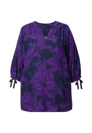 Paarse bloemen tuniek op een donkerblauwe achtergrond, met een V-hals, pofmouwen en strikdetails bij de manchetten. Glad materiaal.