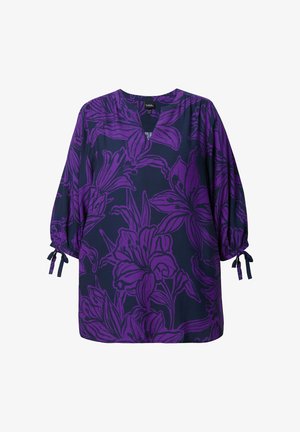 Tunika floreale viola su sfondo blu scuro, con scollatura a V, maniche puff e dettagli con fiocco sui polsini. Tessuto morbido.