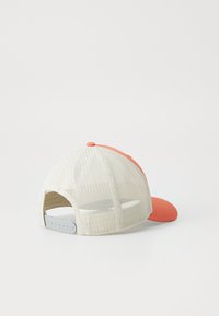 Cap with a coral front panel and visor, beige mesh back, adjustable snap closure, and a textured surface on the front.