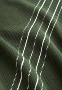 Zelená žebrovaná tkanina s bílými svislými pruhy různé šířky a jemnou texturou. Vhodná pro neformální použití nebo na oděvy.