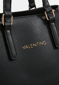 Borsa a mano in pelle nera con superficie testurizzata, caratterizzata da hardware dorato e logo "VALENTINO" in rilievo sul lato, con design a manico doppio.