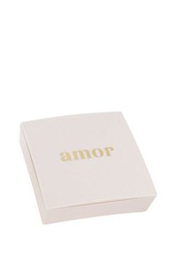 Caja cuadrada de color rosa pálido con una textura suave y lettering dorado que dice "amor" en la parte superior. Diseño minimalista con bordes redondeados.