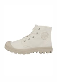 Bottines en toile blanches avec un capuchon en caoutchouc sur le bout, des lacets ronds et une semelle beige texturée. Présente un logo en relief sur le côté.