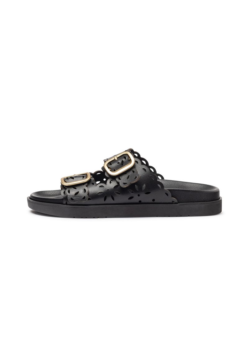Sandalias negras con dos hebillas ajustables, diseño de corte floral, suela plana y textura suave. Estética minimalist y funcional.