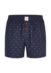 Boxer in blu navy con motivo a pois in rosso chiaro, fascia elastica in vita e due bottoni visibili sul davanti. Realizzati in cotone.