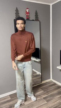 Καφέ πουλόβερ με ζιβάγκο και μανσέτες με ρίγες, συνδυασμένο με ανοιχτόχρωμο τζιν και λευκά αθλητικά παπούτσια. Ο χώρος διαθέτει καθρέφτη και χριστουγεννιάτικη διακόσμηση.