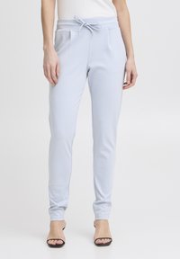 Ljusblå joggingbyxor i mjukt tyg, med elastisk midja och dragsko, två sidofickor och avsmalnande ben.