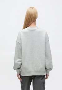 Ανοιχτό γκρι, υπερμεγέθη φούτερ με χαμηλωμένους ώμους, ριμπ λαιμόκοψη και μανσέτες, με απαλό, υφασμάτινο υλικό και χαλαρή εφαρμογή.