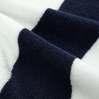 Πετσέτα από βαμβάκι με εναλλασσόμενες ρίγες σε σκούρο ναυτικό μπλε και λευκό· υφή με υψηλό πέλος για απαλότητα και απορροφητικότητα.