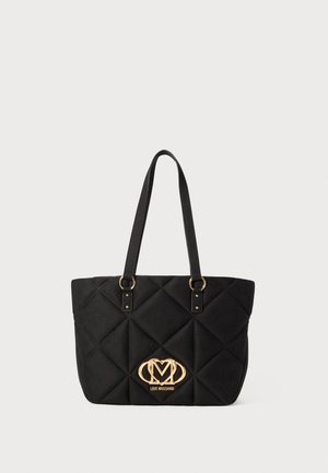 Črna prešita torba z zlatim logotipom, ki ima dva ročaja in gladko, teksturirano površino. Pravokotna oblika, minimalističen dizajn.