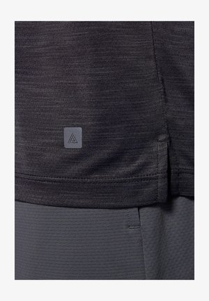 Dunkelgraues Sportshirt aus strukturiertem Stoff. Mit einem seitlichen Schlitz am Saum und einem kleinen Logo-Tag in der unteren linken Ecke.