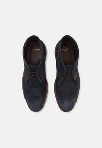 Morske zamoracne čizme od suede materijala s smešnim gumiranim đonom, okruglim vrhom i vezanjem. Imaju utisnuto ime branda na ulošku.