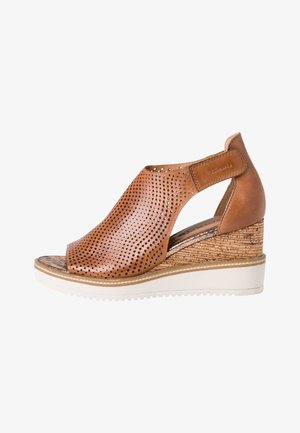 Braune, durchbrochene Leder-Wedge-Sandale mit offener Zehe, Korkmuster-Absatz und weißer Gummisohle. Verfügt über einen Seitenriemen zur Unterstützung.