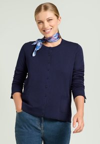 Cardigan blu navy con scollo rotondo, maniche lunghe, chiusura frontale con bottoni e due tasche anteriori. Tessuto a maglia morbida con una texture liscia.