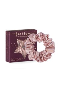 Scrunchie di seta di lusso in rosa tenue, con una texture satinata e piccole perline decorative. Confezionato in una scatola a forma di stella di colore viola scuro.
