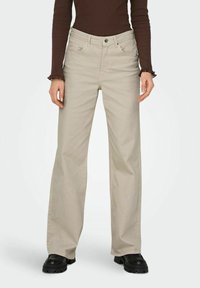 Vaaleanbeiget, leveälahkeiset farkut, joissa on korkea vyötärö, viisi taskua ja napillinen suljenta. Valmistettu kestävästä puuvillakankaasta, jossa on sileä pinta.