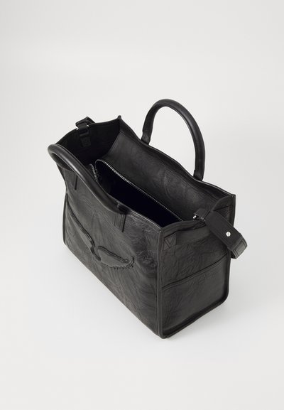 Black leather tote bag with a textured surface, open top, dual handles, and a zippered interior pocket. Includes a decorative front stitch detail.