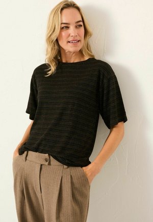 Black short-sleeve t-shirt with textured horizontal stripes. Paired with tan, pleated trousers featuring a single button closure.