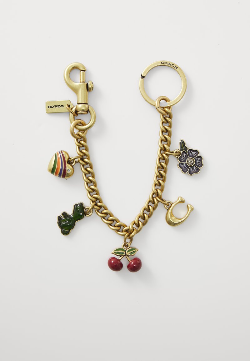 Bracelet en métal doré orné de divers charms en émail : cœur rayé, dinosaure vert, fleur violette et cerises rouges avec des feuilles vertes.