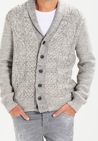 Cardigan grigio lavorato a maglia con colletto a scialle, caratterizzato da motivi testurizzati e sei bottoni neri sulla parte anteriore. Polsini e orlo a coste.