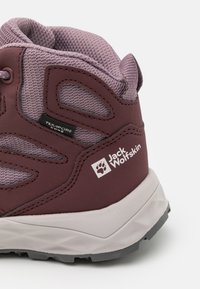 Pantofii de drumeție violet și burgund cu un material superior din plasă, talpă din cauciuc și accente texturate. Include marcajul de brand și eticheta de impermeabilitate.