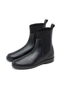 Botas de tobillo de cuero negro con paneles laterales elásticos acanalados, textura suave, punta redonda y tacón bajo cuadrado. Incluyen tiradores para facilitar su uso.