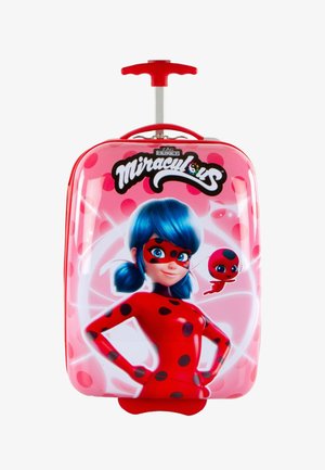 Maleta rígida rosa con un personaje de dibujos animados con cabello azul y manchas rojas, acentuada por un mango rojo y un carrito plateado retráctil.