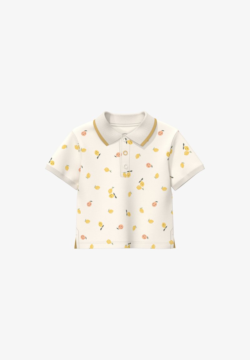 Polo crème à manches courtes avec motifs de fruits jaunes et pêche, bordure moutarde sur le col, et trois boutons sur la patte de boutonnage.