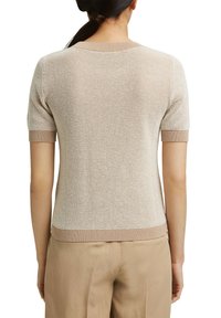 Lyhythihainen, beige neulepaita, jossa on teksturoitu kangas ja ribbireunukset. Sillä on pyöreä kaula-aukko ja tiukka malli.