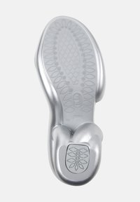 Silver shoe sole with a textured pattern, featuring a rounded shape and a checkered grip. Embossed logo on the heel area.