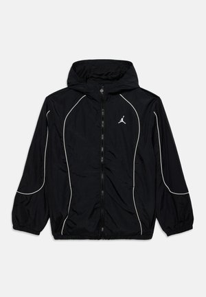 Czarna wiatrówka z kapturem, białymi lamówkami na rękawach i przodzie, pełnym zamkiem błyskawicznym, elastycznymi ściągaczami i małym białym logo Jumpman na piersi.