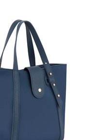 Marineblauwe tote bag van textuur leer, met dubbele hengsels en een voorklep die is beveiligd met een gouden drukknoop. Verstelbare strap. 