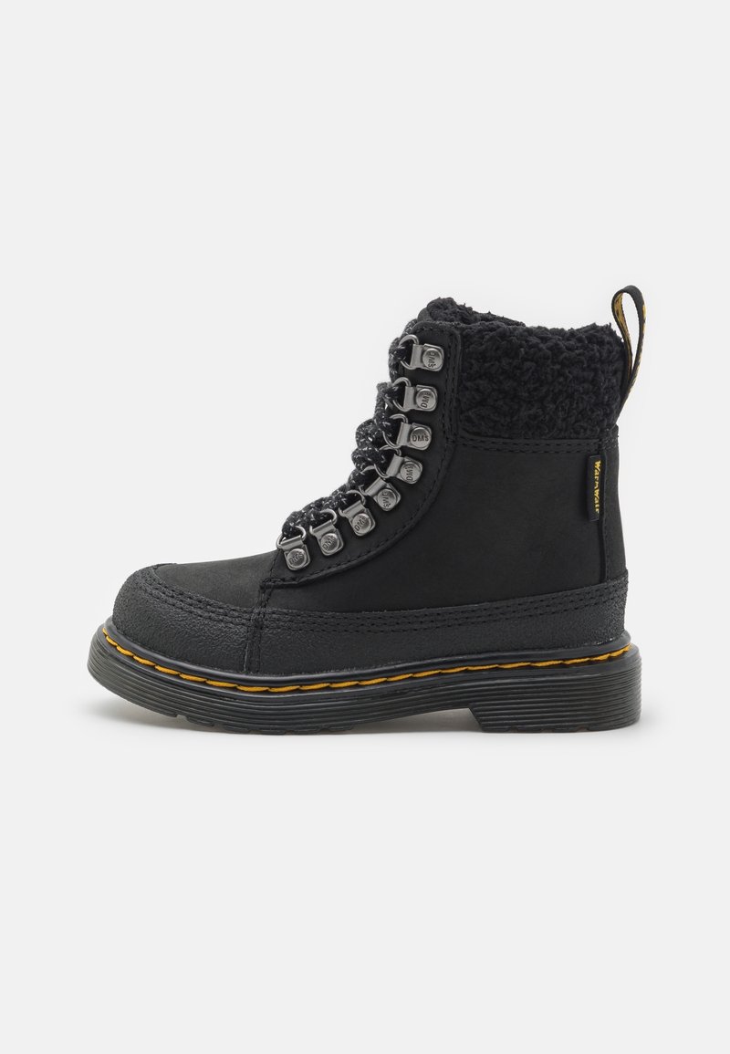 Bottine noire à cheville avec semelle épaisse, surpiqûres jaunes, œillets métalliques, laçage à l'avant et col en polaire doux sur fond blanc.