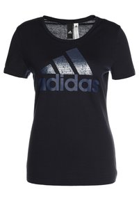 Černé bavlněné tričko s krátkým rukávem a kulatým výstřihem, na přední straně s velkým tmavě modrým logem adidas a texturovaným grafickým vzorem nad ním.
